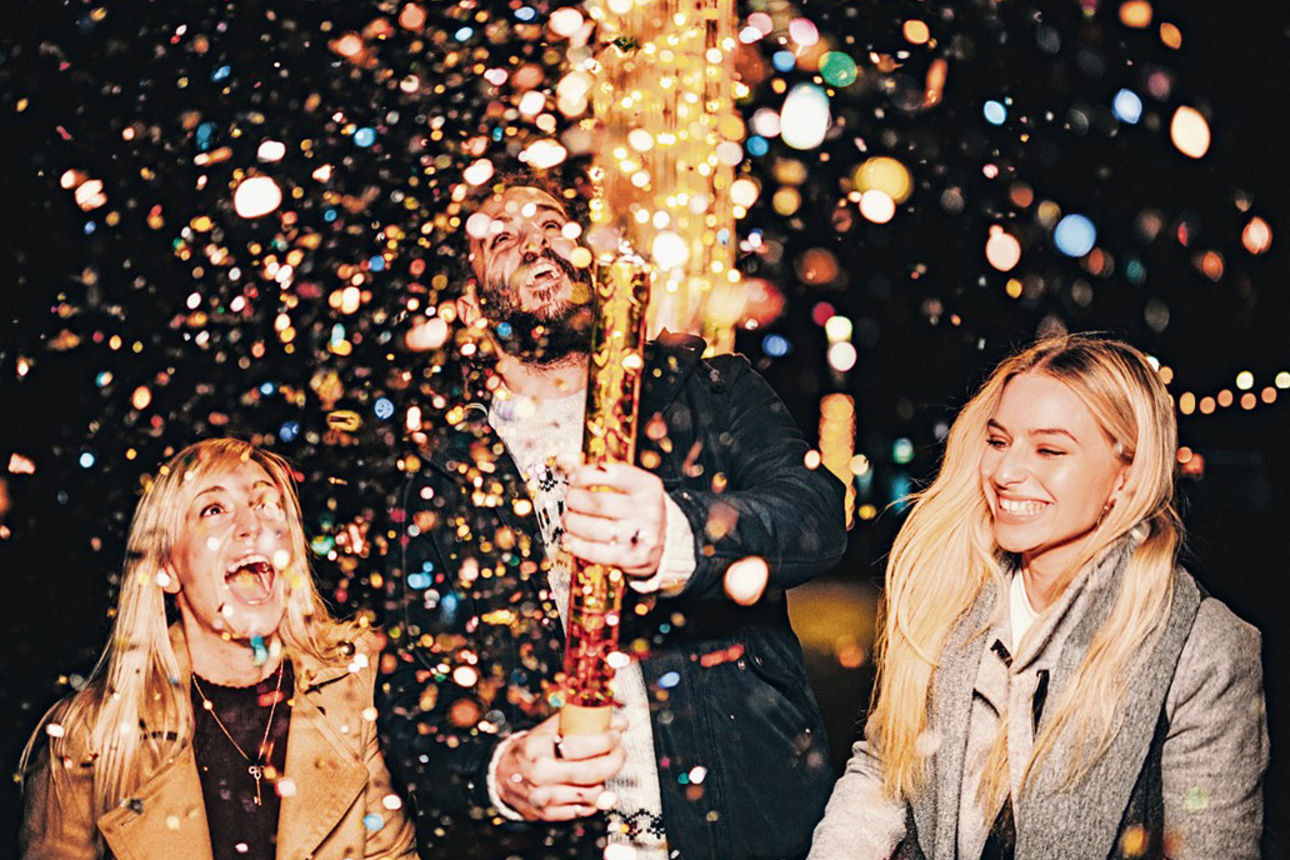 Drei Personen zünden eine Konfettikanone