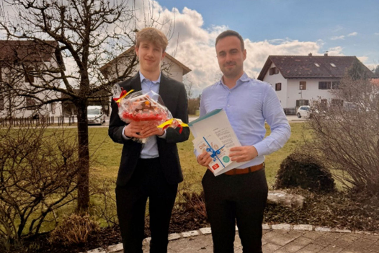 Zwei Männer stehen nebeneinander, beide halten Präsente in den Händen