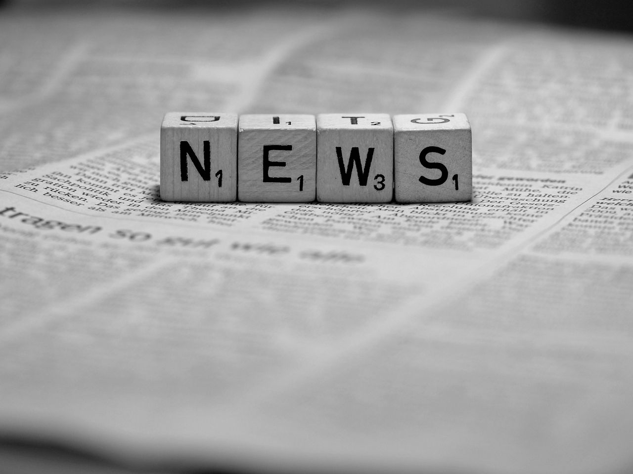Eine Zeitung mit Scrabble-Steinen und Schrift News