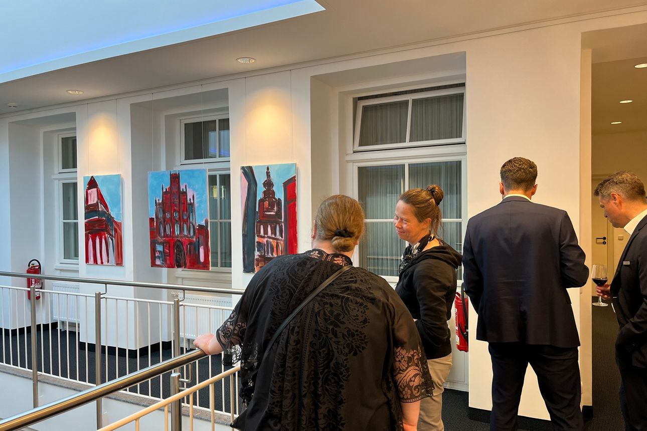Menschen besuchen die Ausstellung in der Volksbank Vorpommern