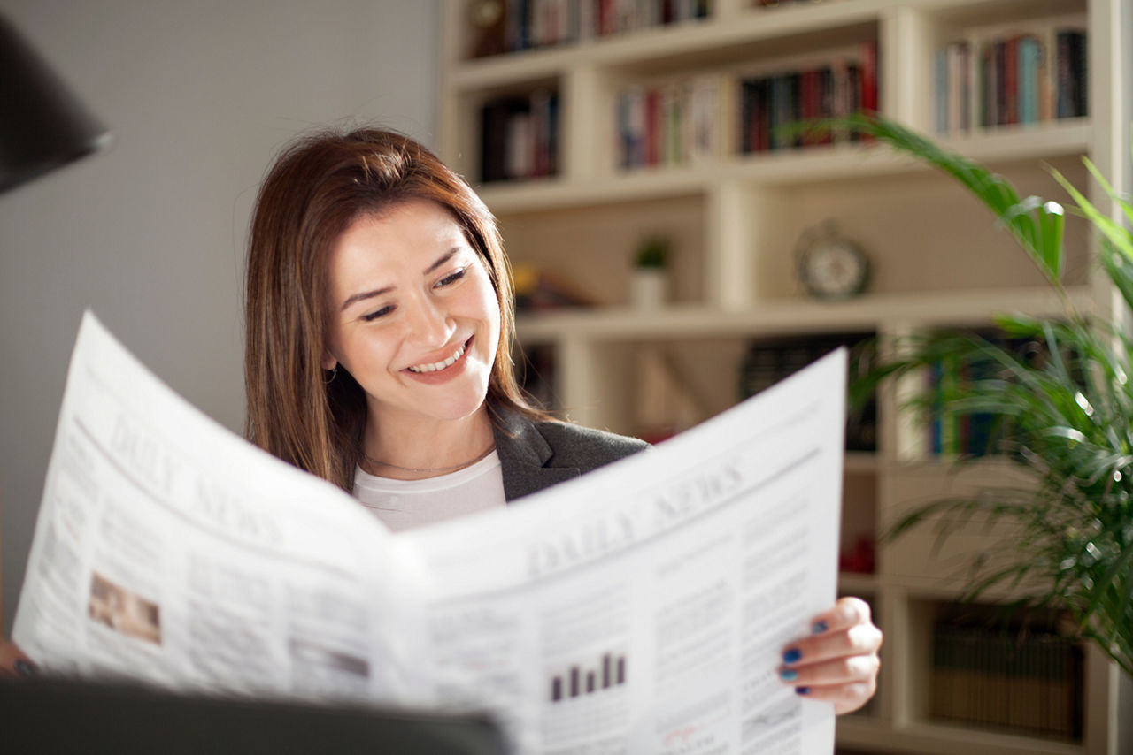 Eine junge Frau ließt die Tageszeitung