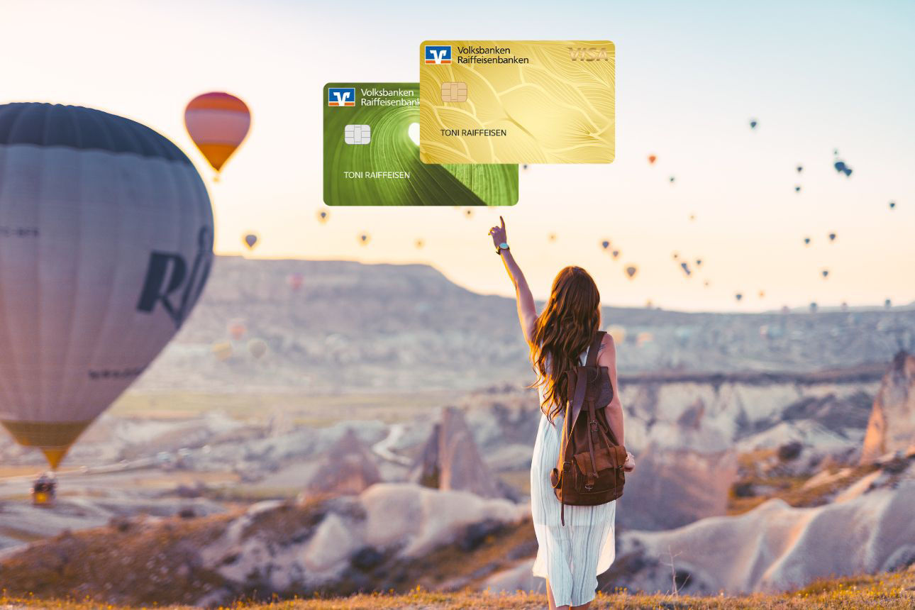 Frau mit Rucksack mit Blick ins Tal mit Heißluftballon und Kreditkarten