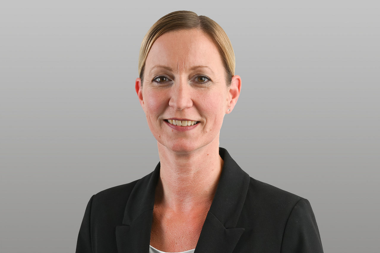 Privatkundenberaterin Simone Nimmerrichter vor grauen Hintergrund
