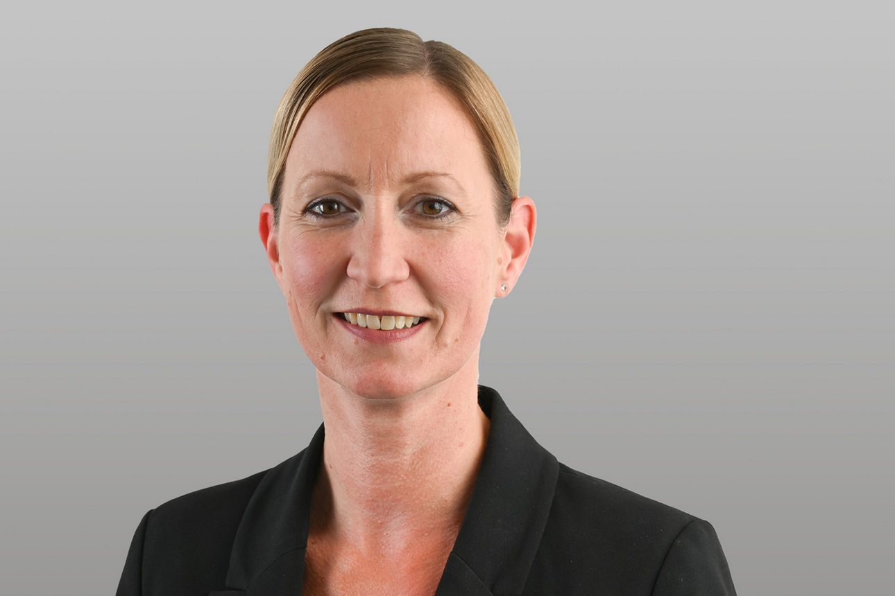 Privatkundenberaterin Simone Nimmerrichter vor grauen Hintergrund