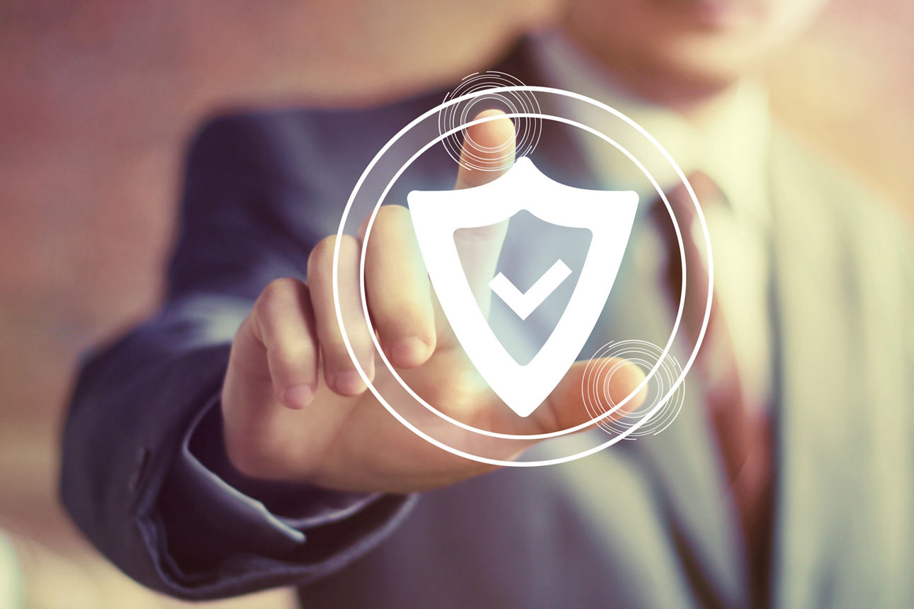 Geschäftsmann drückt mit dem Finger auf ein Schild mit einer Sicherheit-Symbol