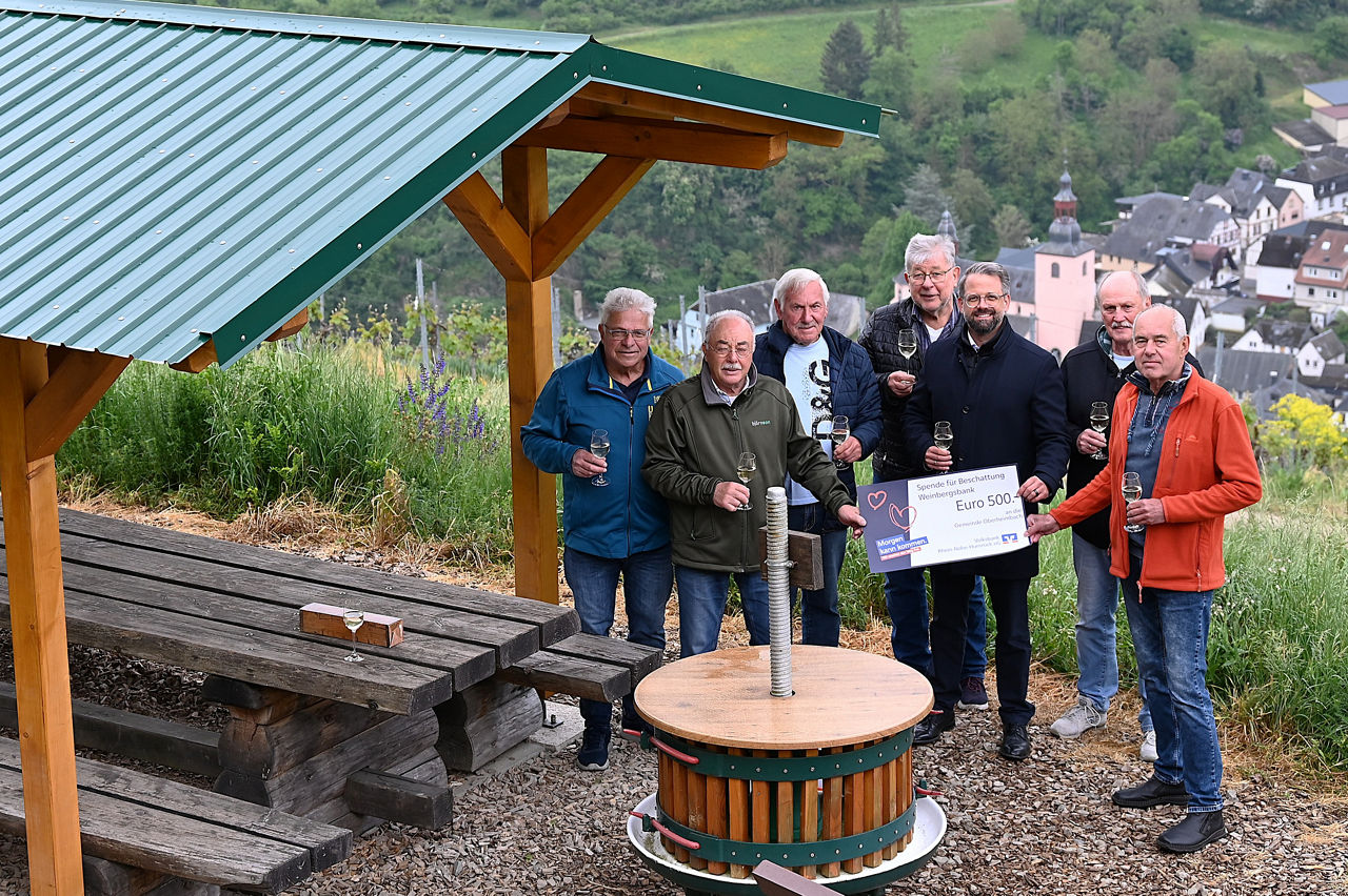 Erwachsene halten einen Spendenscheck in der Hand.