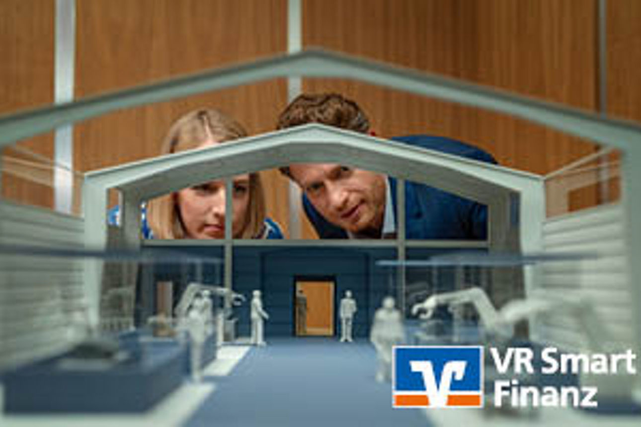 Mann und Frau schauen auf ein Modell einer Lagerhalle