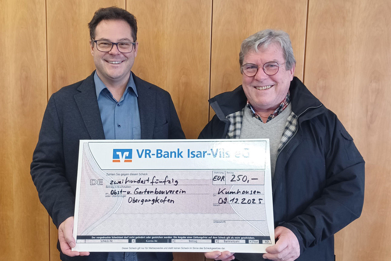 Zwei Männer lächeln in die Kamera. Sie halten einen Riesenspendenscheck in der Hand.