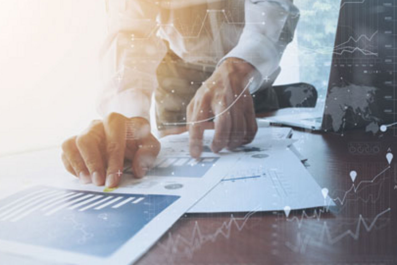 Mann im Hemd hat Ausdrucke mit Diagrammen vor sich