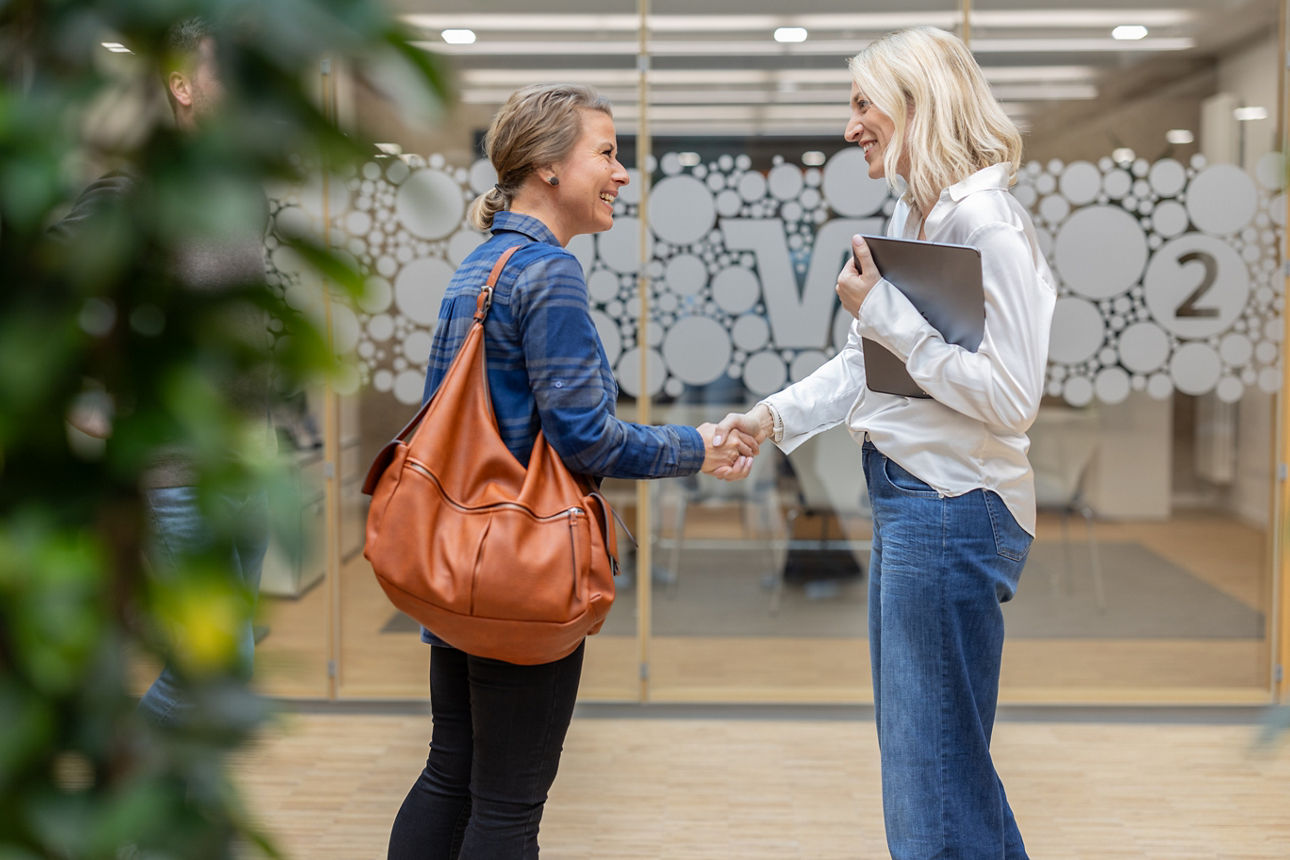 Zwei Frauen geben sich die Hand