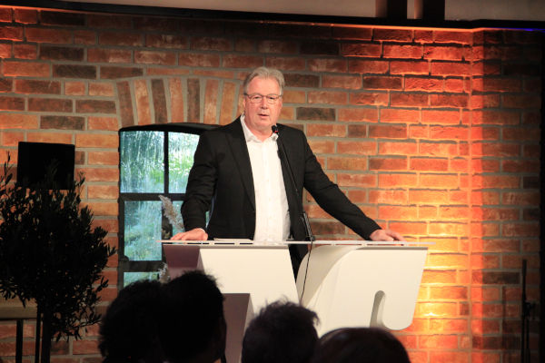 Oliver Cichowski standing at a pulpit and giving a speech