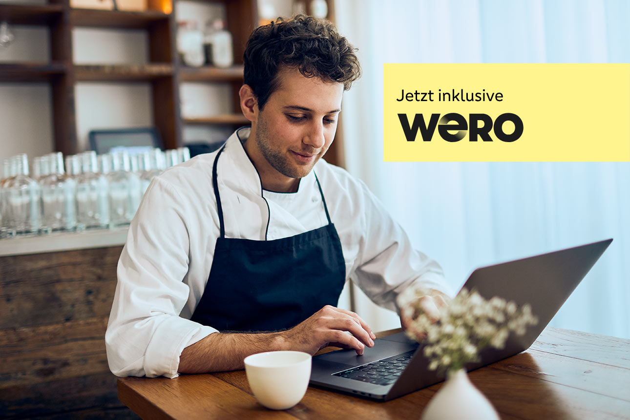 Mann mit Hemd und Schürze arbeitet am Laptop