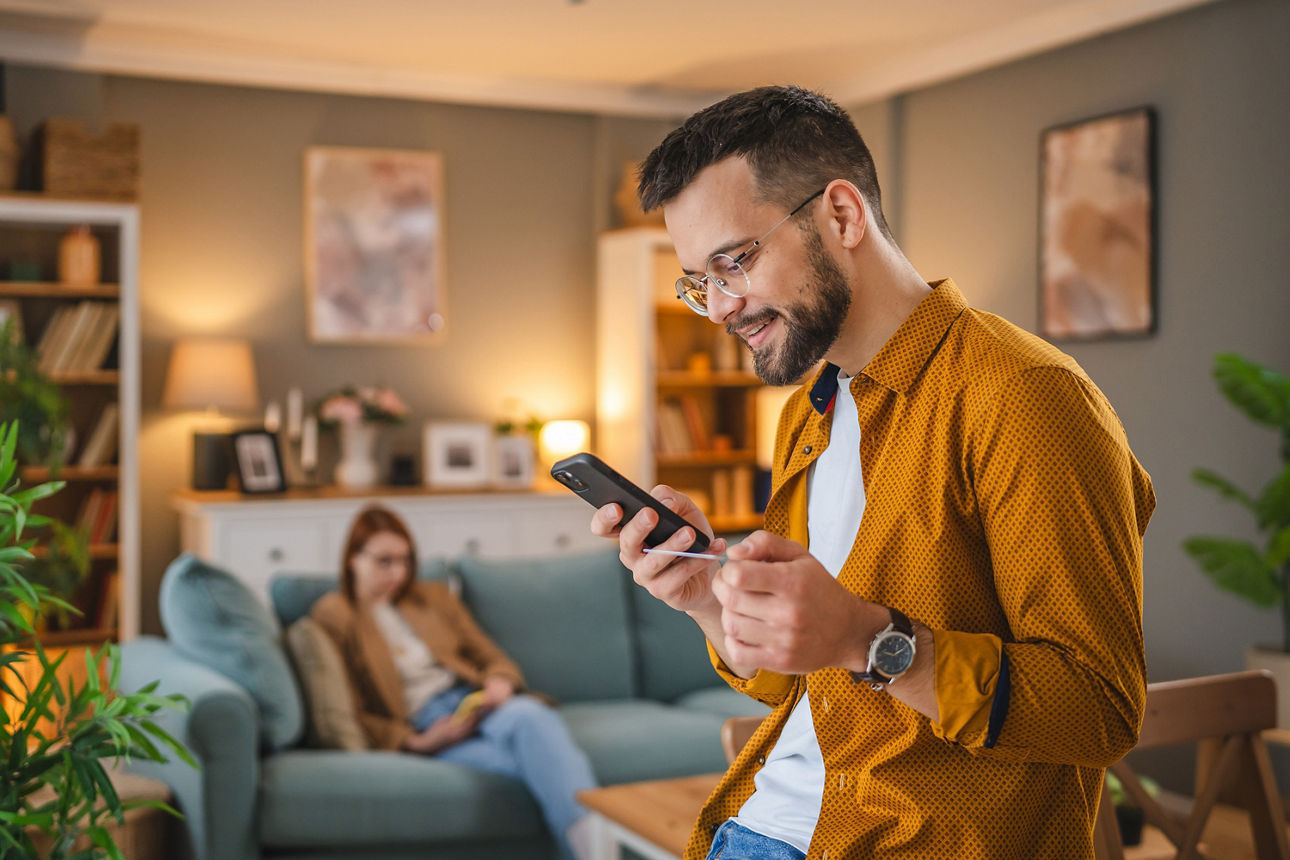 Mann hält sein Handy in der Hand und macht Onlinebanking