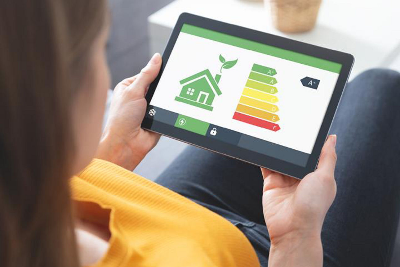 Frau sitzt mit Tablett in der Hand und darauf ist eine Energie-Grafik