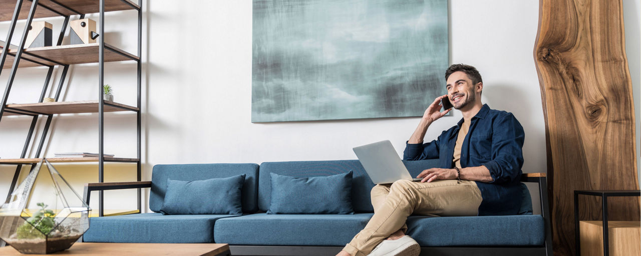 Mann auf dem Sofa mit Tablet und Telefon