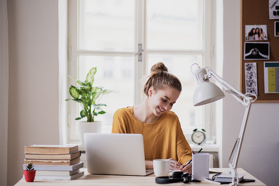 Eine junge Frau arbeitet an ihrem Laptop
