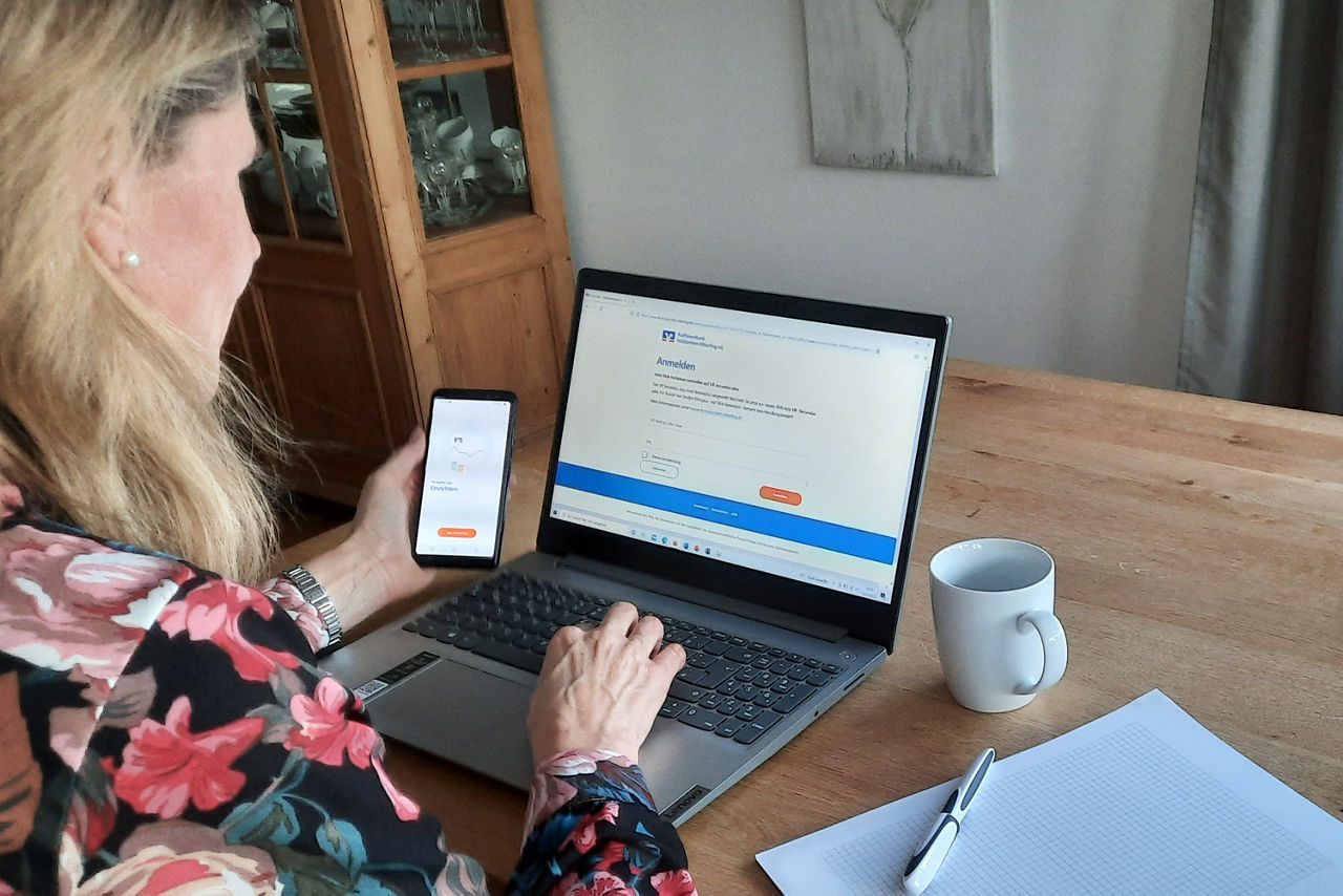 Frau mit Handy am PC