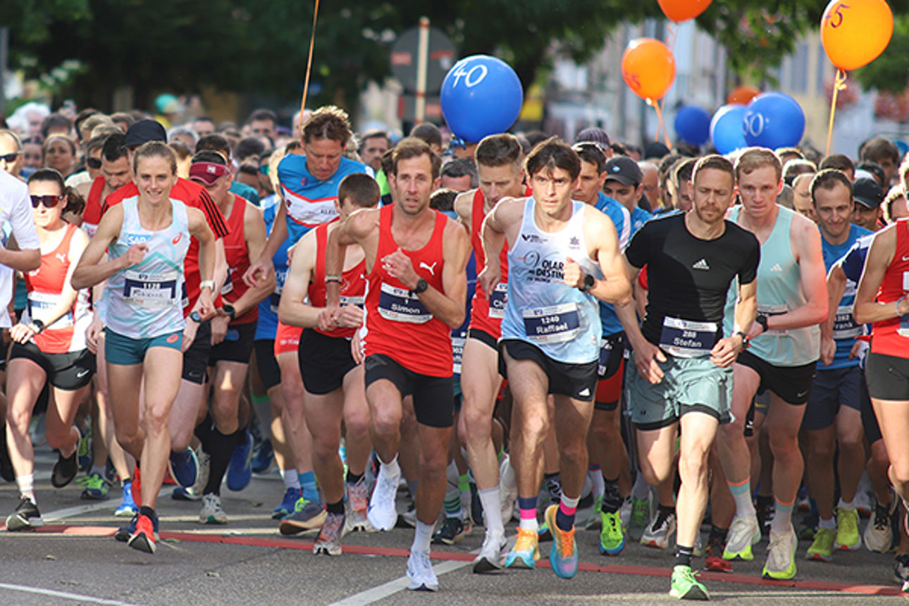 Viele Läuferinnen und Läufer laufen von einer Startlinie los.