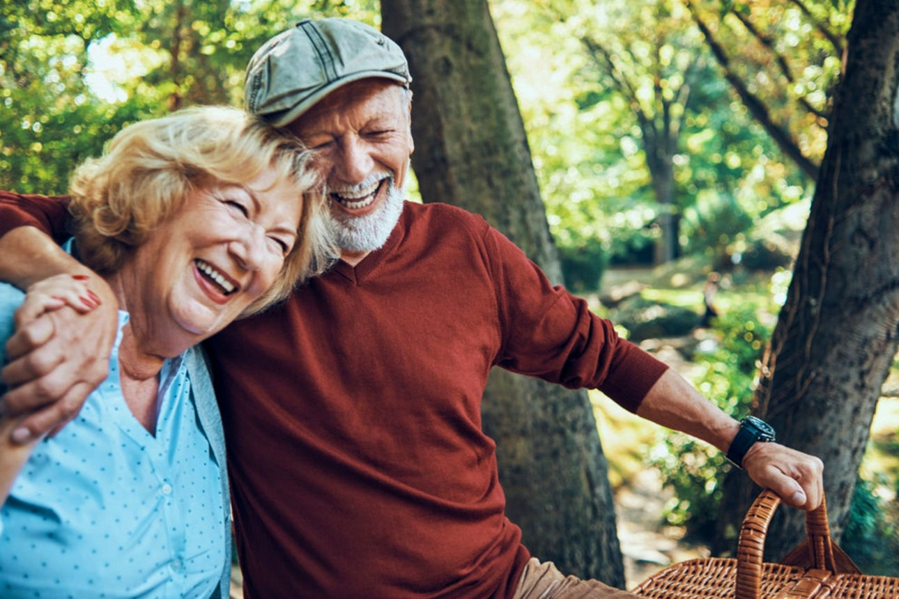 Altes Ehepaar liegt sich lachend in den Armen