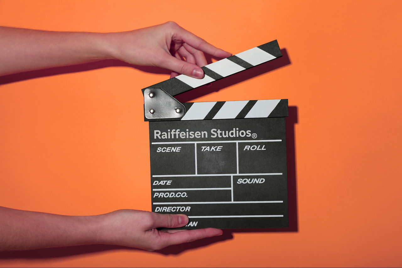 Eine FIlmklappe wird vor einer orangen Wand gehalten