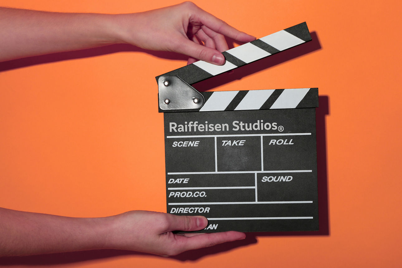 Eine FIlmklappe wird vor einer orangen Wand gehalten