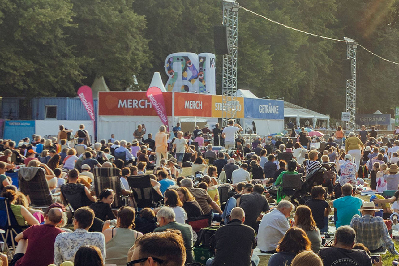 Feiernde Menschenmenge bei einem Konzert vor einer Bühne