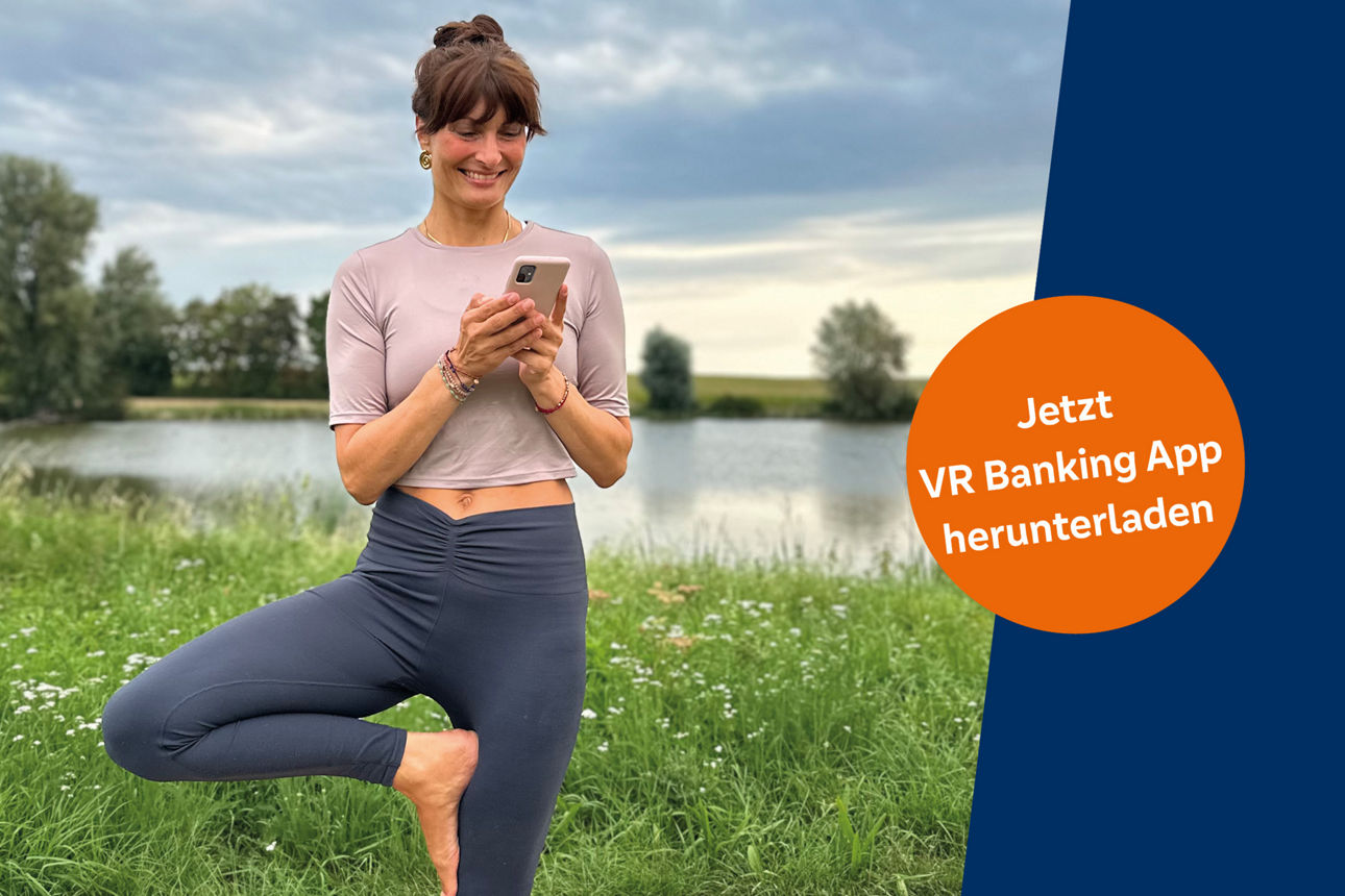 Junge Frau mit Cafe To-go-Becher und Smartphone in der Hand schaut in die Kamera