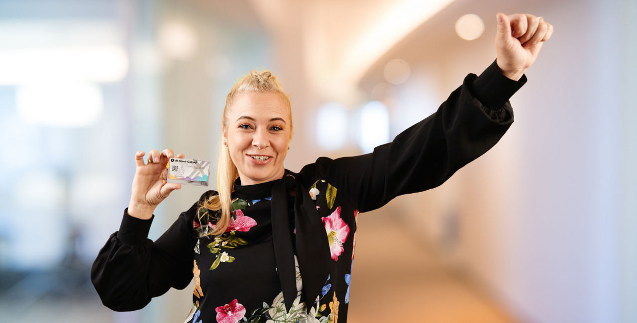 Junge blonde Frau hält BitcoinGo-Karte in der Hand