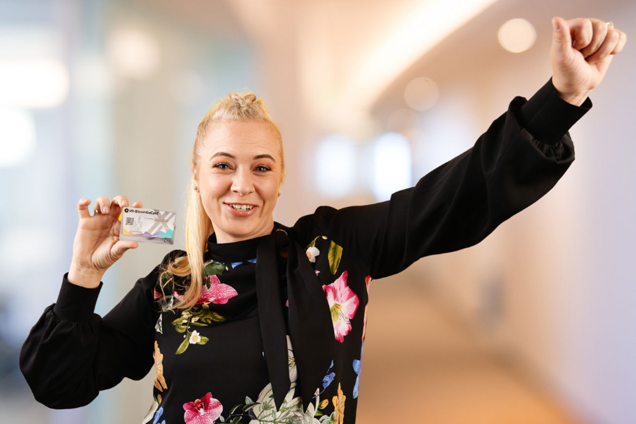 Junge blonde Frau hält BitcoinGo-Karte in der Hand