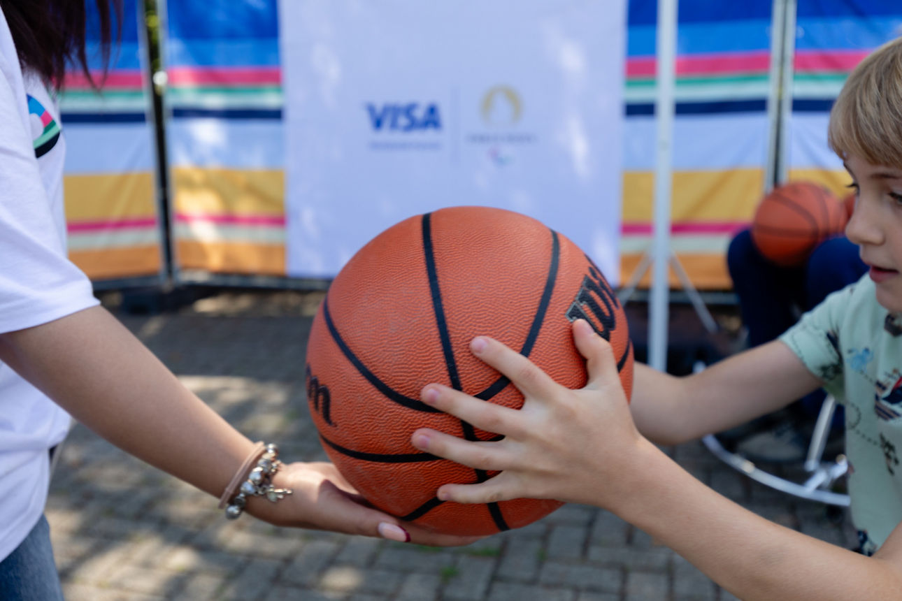 Hände die gemeinsam einen Basketball anfassen