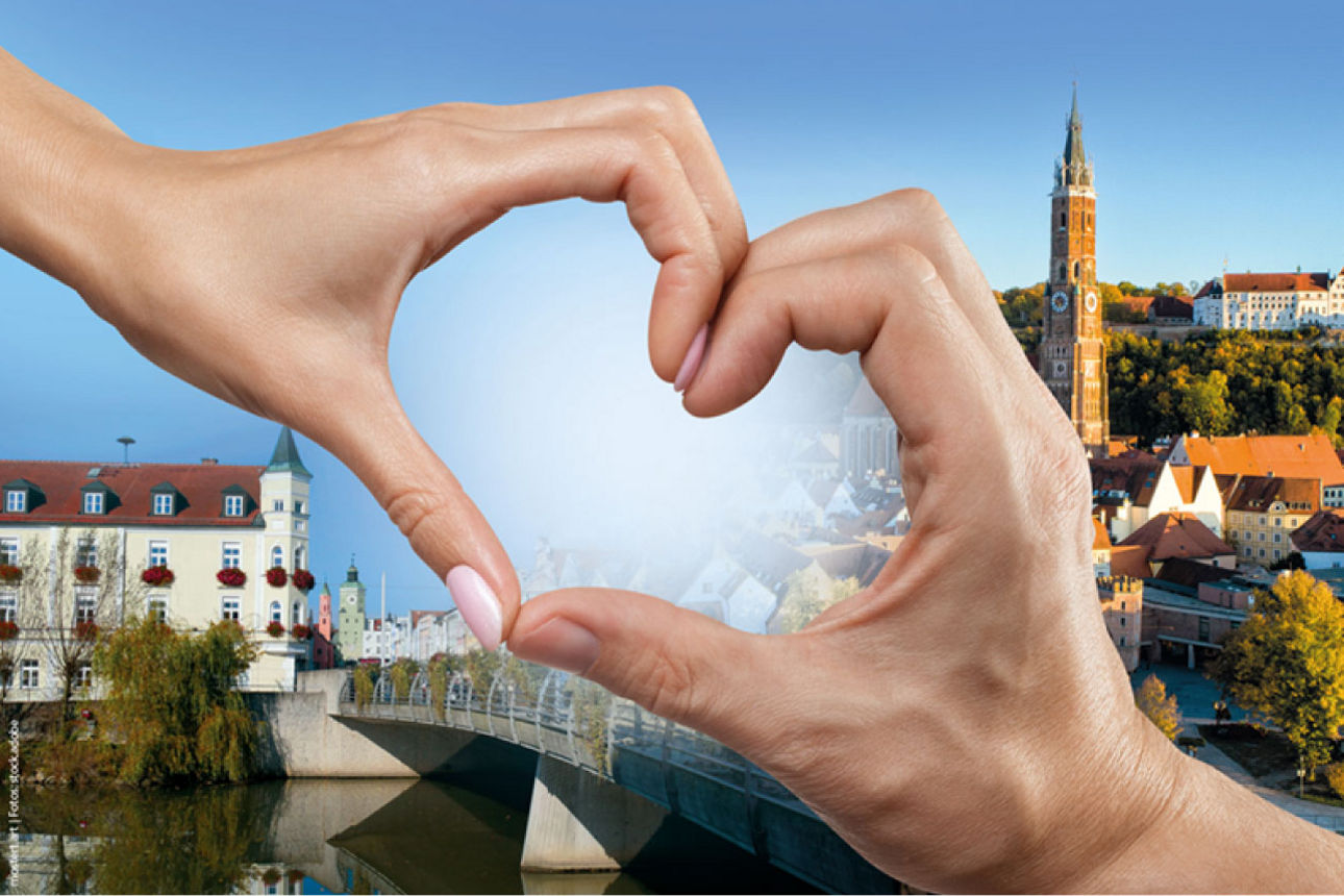 Zwei Hände die ein Herz formen über den Städten Landshut und Vilsbiburg