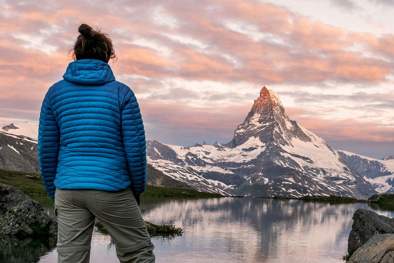 Eine weibliche Touristin genießt den Blick auf das Matterhorn in den frühen Morgenstunden in den Walliser Alpen, Schweiz.