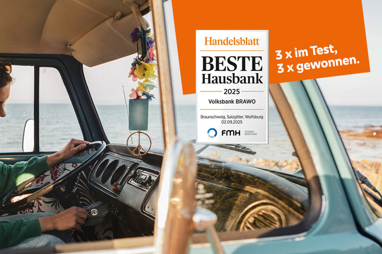 Eine Frau und ein Mann sitzten in einem Camper und frahren an einer Küste entlang, man sieht das weite Meer im Hintergrund