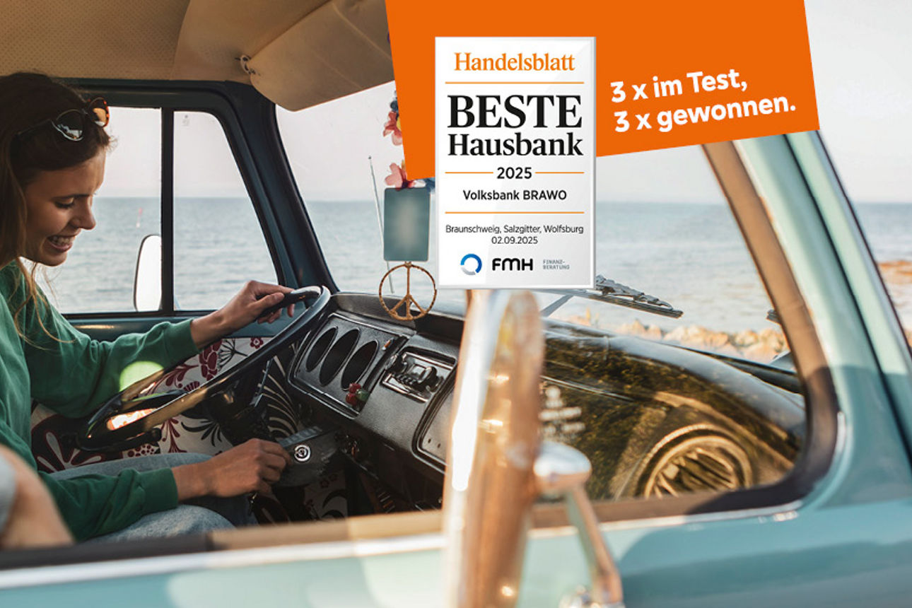 Eine Frau und ein Mann sitzten in einem Camper und frahren an einer Küste entlang, man sieht das weite Meer im Hintergrund