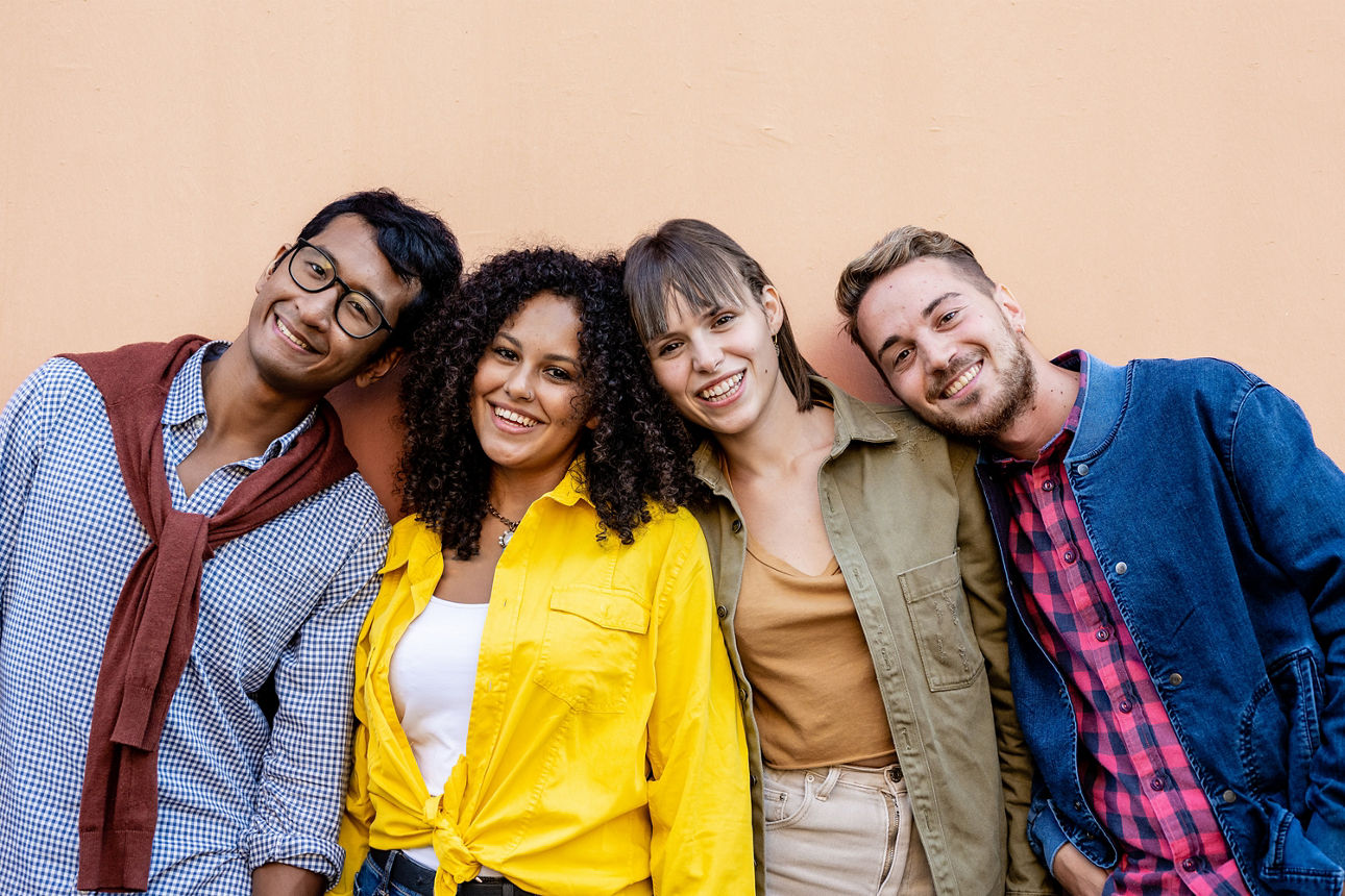 Vier Personen stehen lächelnd nebeneinander