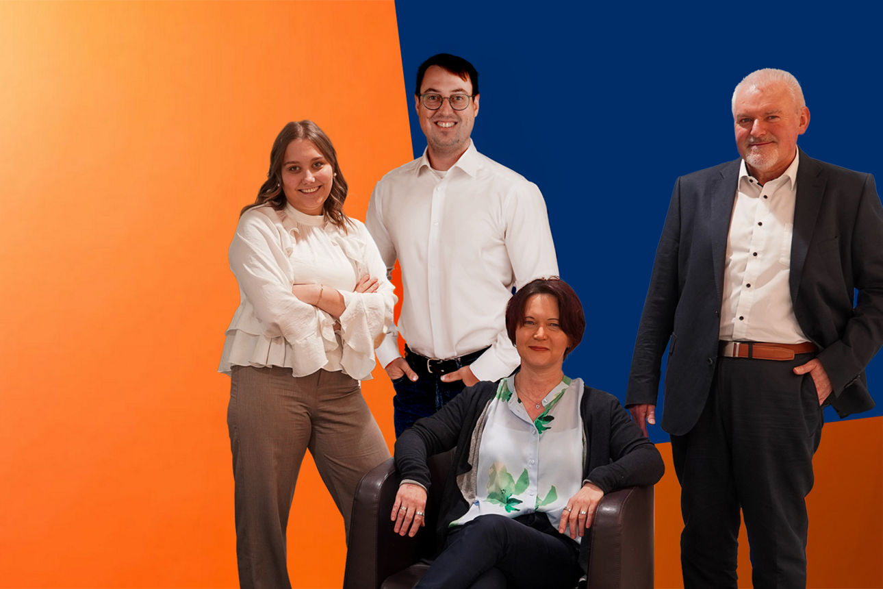 Mitarbeiter vor orange-blauer Wand