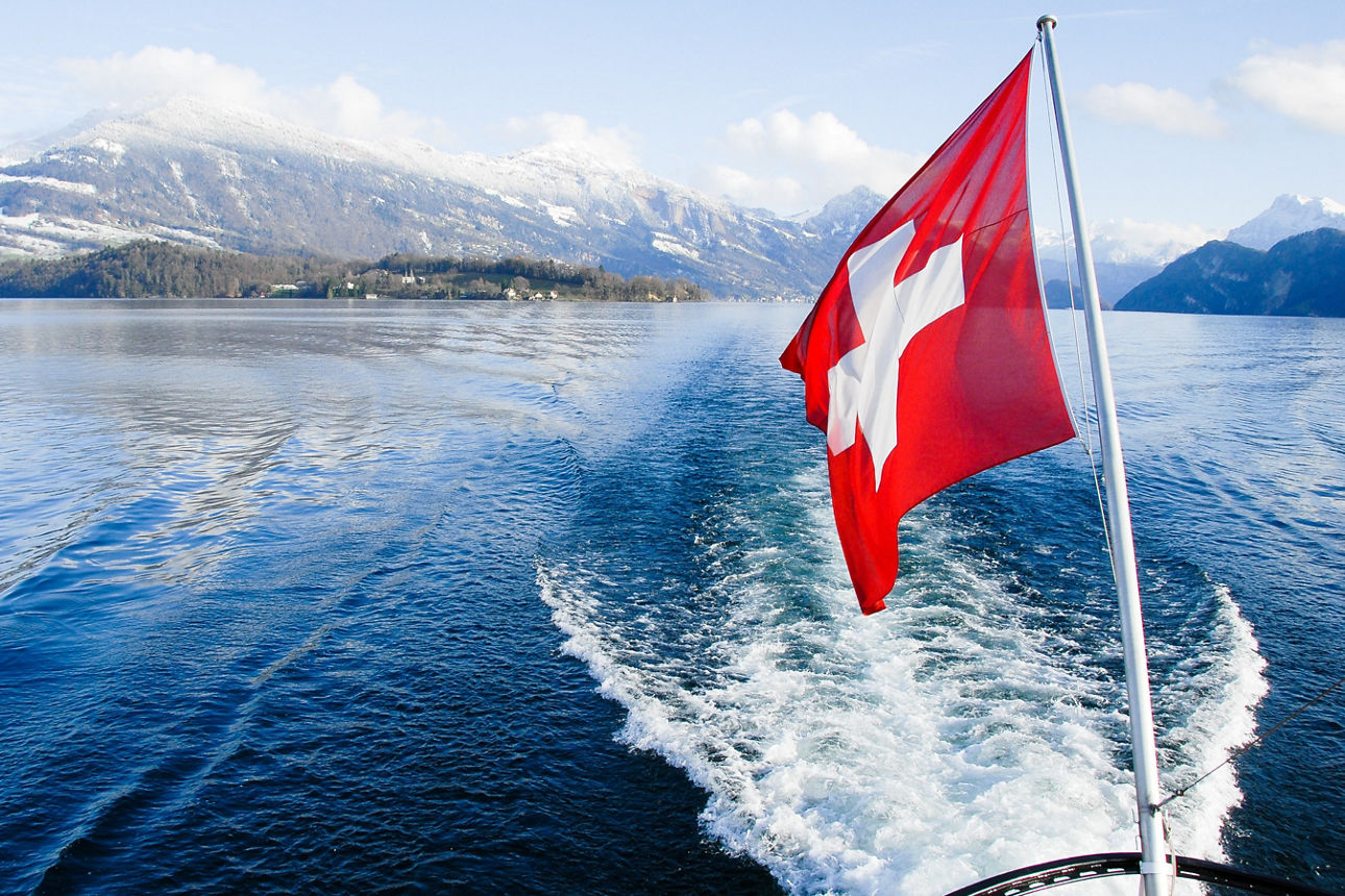 Ein See mit einer Schweizer Flagge zu sehen. 