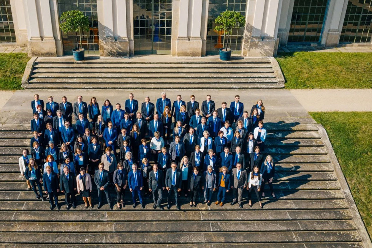 Alle Volksbank-Mitarbeiter auf der Treppe im Barockgarten Großsedlitz, in Business-Kleidung, von oben fotografiert