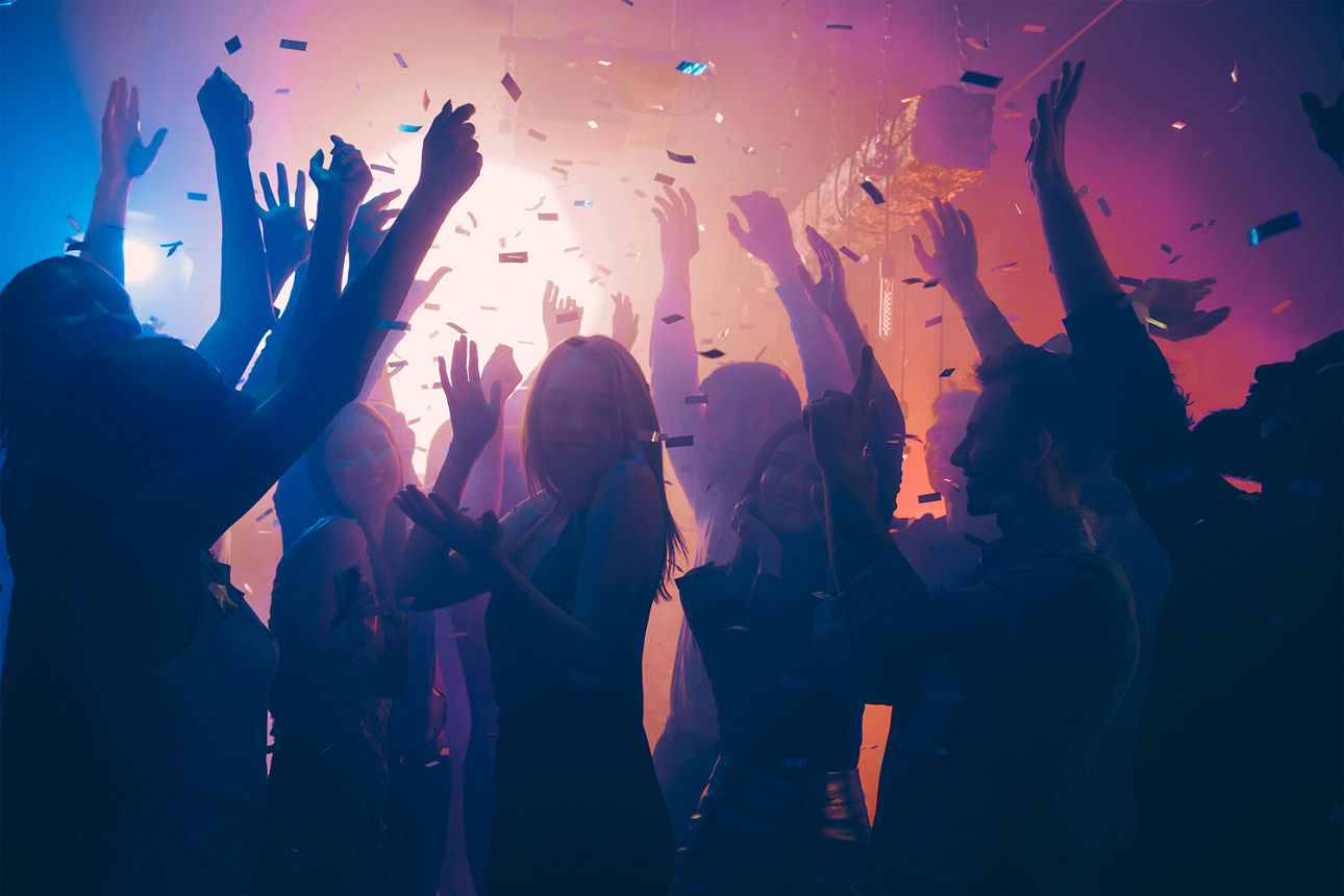 Tanzende feiernde Menschen im Scheinwerferlicht