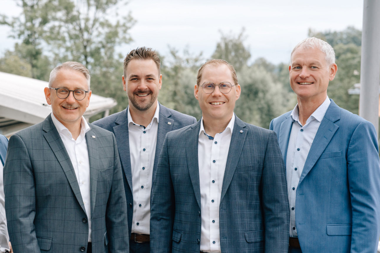 Unsere fünf Männer vom Führungskreis stehen nebeneinander auf einer Dachterrasse und schauen nach vorne.
