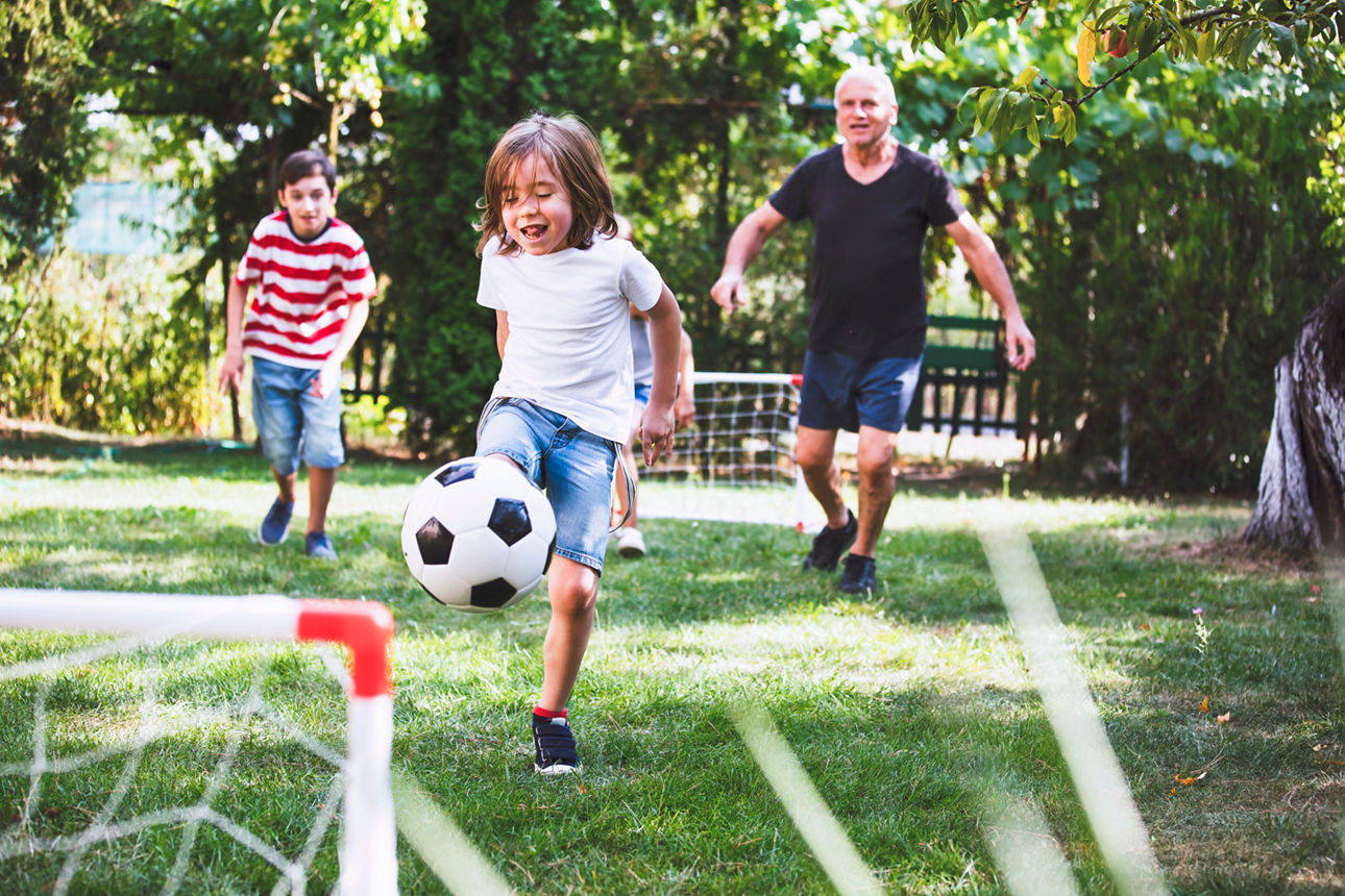 Familie spielt in Garten Fußball
