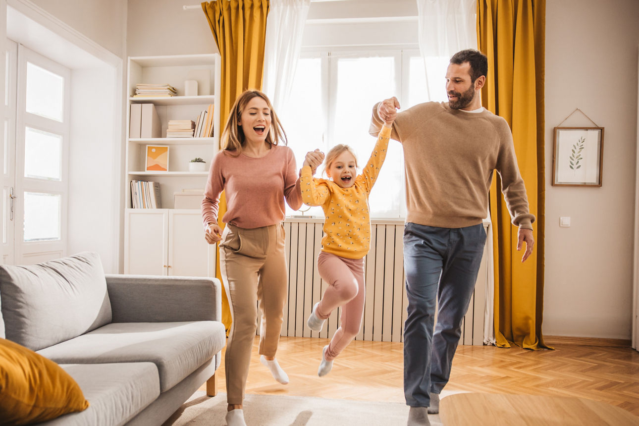 Junges Paar spielt mit Kleinkind in Wohnung