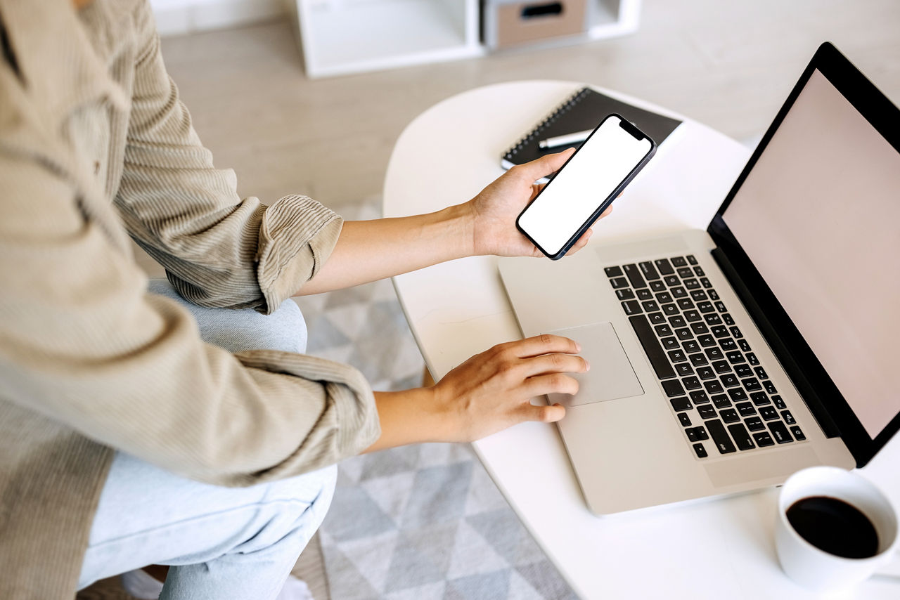 Frau arbeitet mit Handy und Laptop