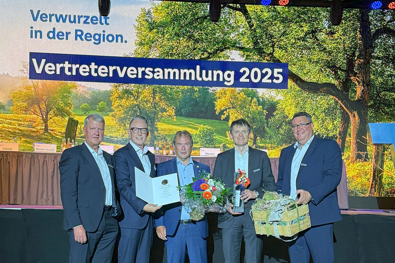 Helmut Vilmar (Vorstand), Tobias Jasper (Bankenbetreuuer Genoverband e. V.), Norbert Orbach, Christoph Gubert (Vorstand), Jörg Meuten (Aufsichtsratsvorsitzender) stehen vor einer Leinwand