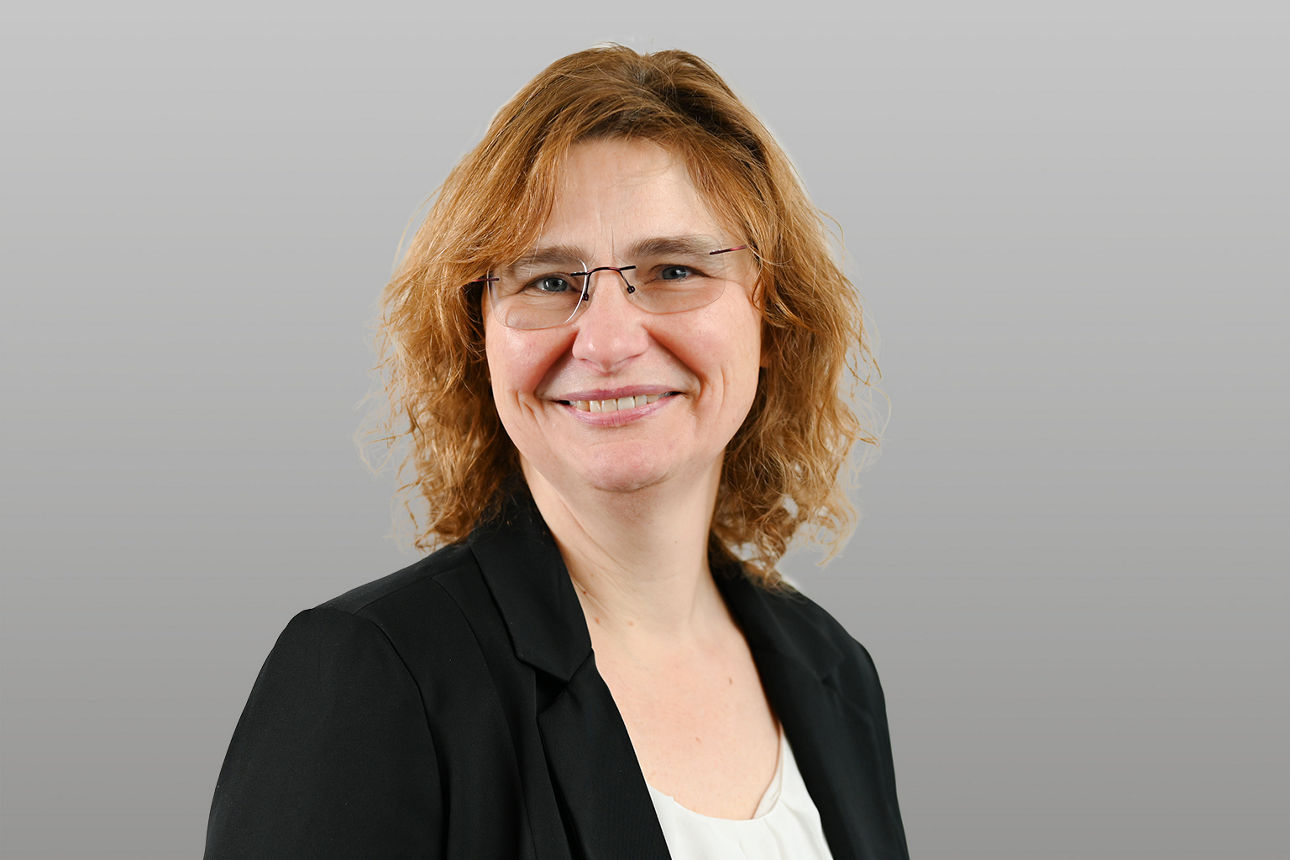 Privatkundenberaterin Stephanie Over vor grauen Hintergrund