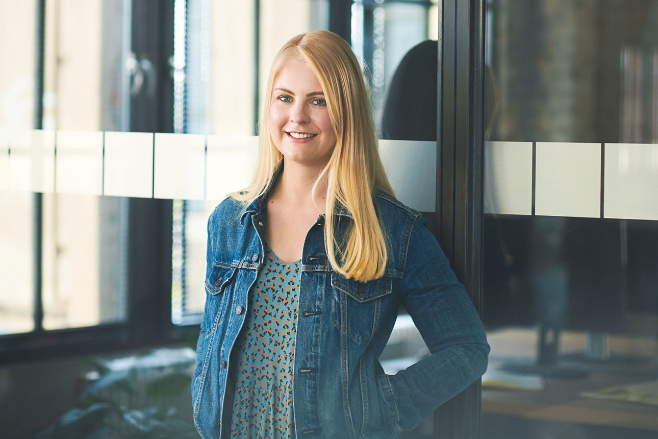 Junge Frau steht vor einer Glastür