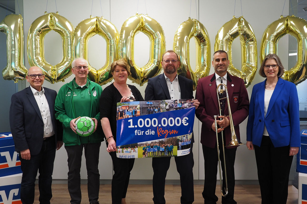 Sechs Personen vor goldenen „1 000 000“-Ballons mit Banner „1.000.000 € für die Region“.