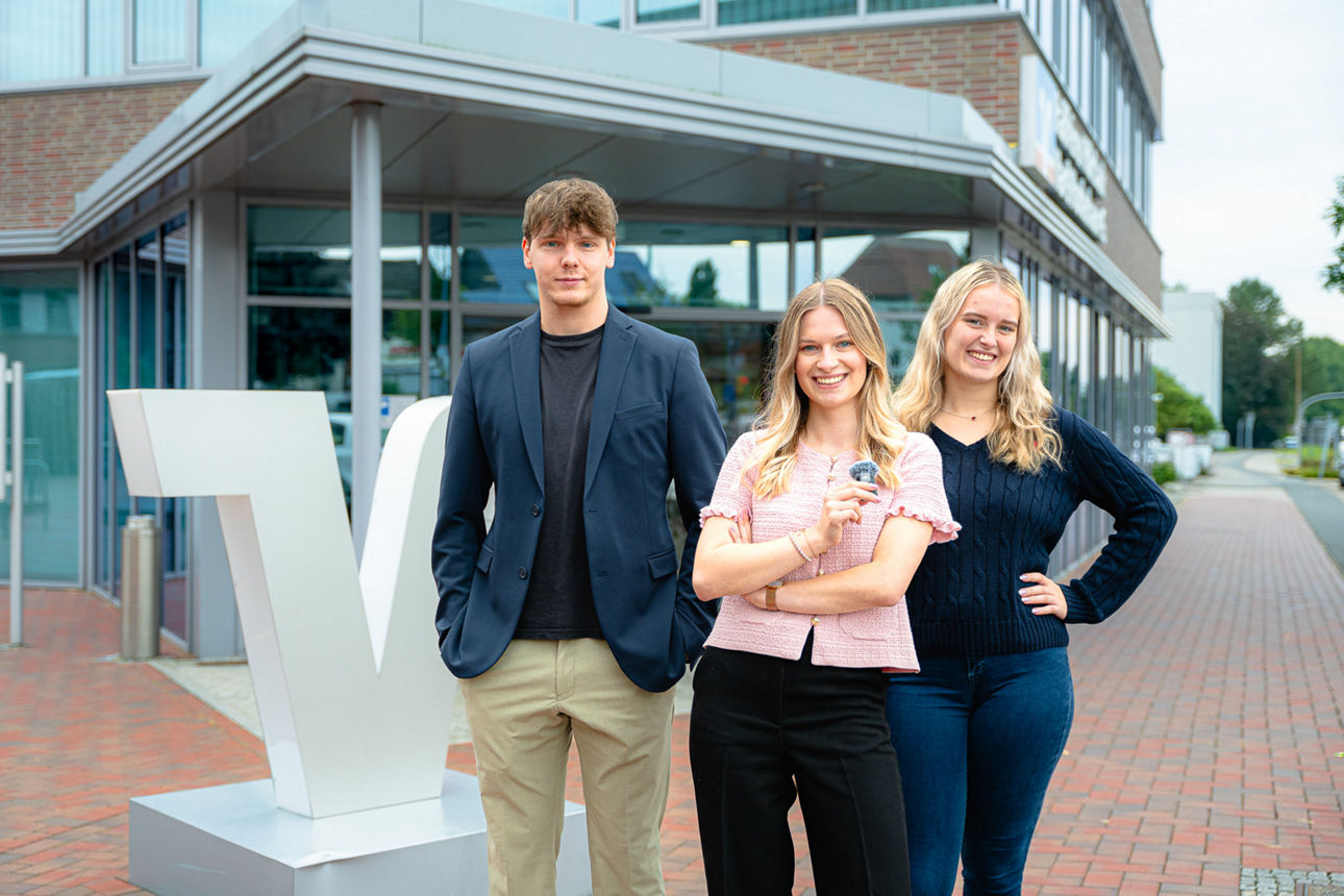 Drei Azubis vor dem Bankgebäude
