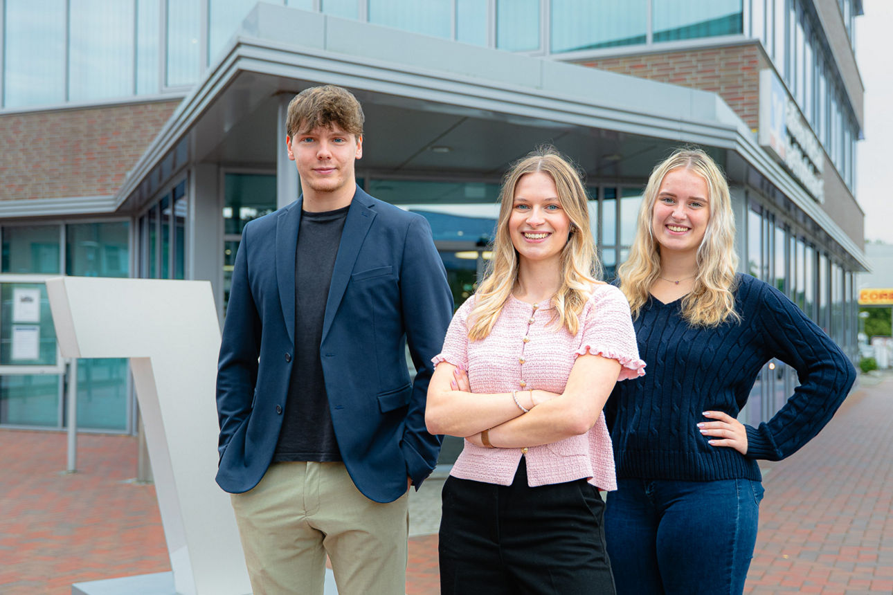 Drei Azubis vor dem Bankgebäude