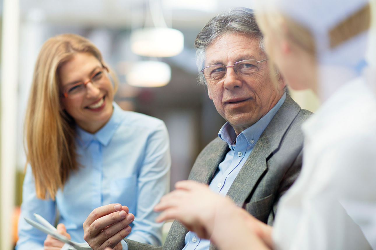 Drei Geschäftsleute, die sich in einem Meeting unterhalten